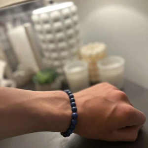 Blått pärlarmband med stenar - Snyggt armband med runda blå pärlor i stenlook. Elastiskt band gör det enkelt att ta på och av. Perfekt accessoar för att ge din outfit lite extra färg och stil.