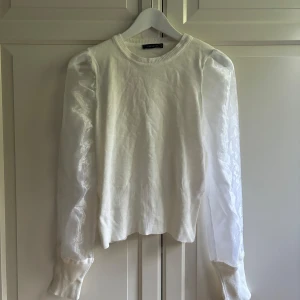 Vit tröja med puffiga meshärmar - I nyskick, skrynklig pga att den legat nerpackad i en kartong.