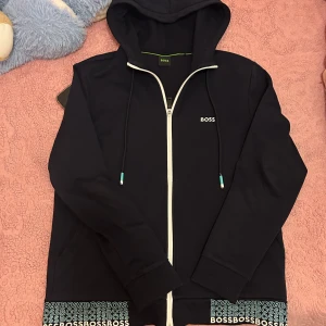 Boss tröja  - Svart hoodie från BOSS riktig fett nu under sommar den är sparsamt inte använt mycket nästan som ny. Storlek M men passar S. Bara höra av er vid frågor 