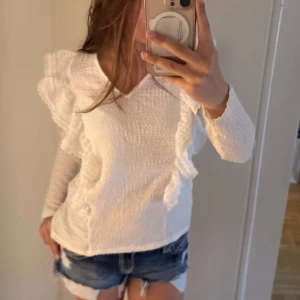 Vit blus med volang från Vila - En vit blus med volanger från vila, den har används 2-3 ggr och har inga tecken på användning, säljer för den inte kommer till användning 💕