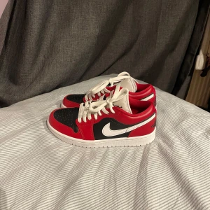 Nike Air Jordan 1 Low röd/svart/vit - Säljer ett par Nike Air Jordan 1 Low med klassisk färgblockning i rött, svart och vitt. Skorna har vit sula, svart tåbox och röda paneler i skinn. Ikonisk vinge på hälen och vit swoosh på sidan. Knappt använda, max 3 gånger. Storlek 36,5 men passar en 37a bra!❤️