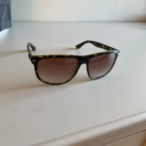 Ray-Ban Boyfriend solglasögon leopard - Snygga Ray-Ban boyfriend solglasögon med leopardmönstrad båge i brunt och svart. Glasen är bruna med lätt toning. Klassisk modell som ger en cool vibe och passar perfekt till sommaren. Ray-Ban-logga på sidan och i glaset.