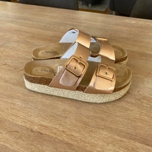 Roséguld sandaler från Duffy - Snygga sandaler i roséguld från Duffy med dubbla spännen och en platåsula i flätad design.