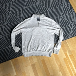 Beige tröja med dragkedja från Bondelid - Säljer en stilren beige tröja från Bondelid med dragkedja i halsen. Tröjan har långa ärmar och ribbade muddar vid ärmslut och nederkant. Perfekt för en avslappnad look.