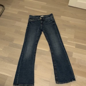 Blå bootcut jeans - Snygga blå bootcut jeans med låg midja och klassisk femficksdesign. Jeansen har en dragkedja och knappar framtill. Perfekta för en avslappnad stil. Ge prisförslag så kan vi diskutera om priset🌟🌟