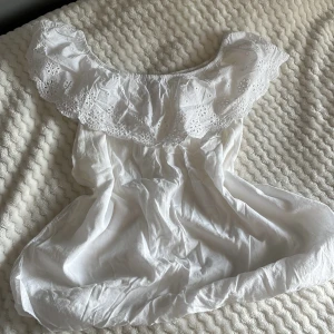 Vit blus från Stajl - Säljer en söt vit blus från Stajl med vackra spetsdetaljer vid halsringningen. 