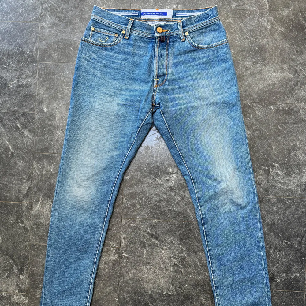 Snygga blå jeans från Jacob Cohën med klassisk femficksdesign och knappgylf. Jeansen har en stilren look med subtila slitningar och kontrastsömmar. Perfekta för en avslappnad stil.. Farkut & Housut.