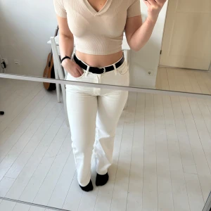 Beige ribbad croppad polotopp - Beige ribbad croppad topp med korta ärmar och v-ringning. 