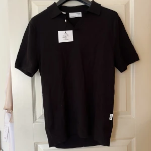Svart pikétröja från Selected Homme - Säljer en stilren svart pikétröja från Selected Homme. Tröjan har korta ärmar och en klassisk krage. Perfekt för en avslappnad men ändå snygg look. Tillverkad med omsorg och kvalitet.