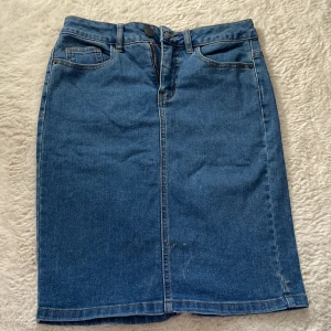 Jeanskjol från Vero Moda - Snygg jeanskjol från Vero Moda i klassisk blå denim. Kjolen har en dragkedja fram och praktiska fickor både fram och bak. Perfekt för en avslappnad stil med en touch av retro. 🦋