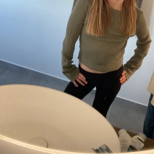 Grön ribbad tröja från H&M - Säljer en stilren grön ribbad tröja från H&M. Tröjan har en croppad passform och långa ärmar, perfekt för en avslappnad look. Den är tillverkad i ett mjukt och bekvämt material.