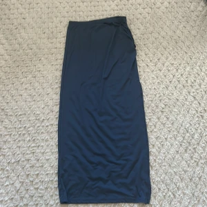 Marinblå  långkjol från Shein - Snygg marinblå  långkjol från Shein i en elegant och enkel design. Kjolen har en elastisk midja för bekväm passform och är perfekt för en stilren look. Tillverkad i ett mjukt och följsamt material.