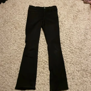 Svarta jeans från ONLY - Snygga svarta jeans från ONLY med en klassisk design. Byxorna har en knapp och dragkedja framtill och är i en bootcut-stil. Perfekta för en stilren look.