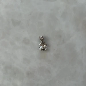 Pandora liknade berlock - Elegant silverfärgat hänge med en klar, gnistrande sten i mitten. Perfekt att sätt på sitt Pandora armband. Köpt på marknad i Spanien 