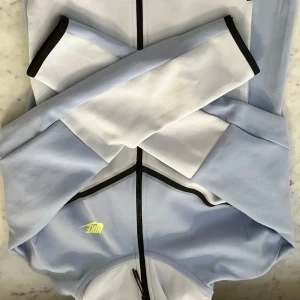 Ljusblå och vit techfleece från Nike - Säljer min aldrig använda Nike tech fleece i färgen baby blue. Anledningen till att den aldrig har varit använd är inte pga skador osv, utan att den köptes för ett bra tag sen då den inte passade, glömdes sedan bort och nu hittad igen. MEN den passar inte så hoppas ngn har behov av den