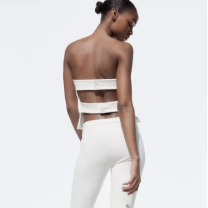 Vit axelbandslös tubtopp - Snygg vit axelbandslös tubtopp med knäppning bak. Perfekt för en stilren look. Storlek L men sitter som s/m. Nypris 259kr