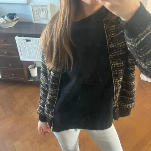 glittrig svart vårjacka från H&M - Säljer en snygg randig jacka från H&M med dragkedja framtill. Jackan har en mix av färger som svart, rosa och gul, vilket ger den ett unikt utseende. Köpt på vinted. Aldrig andvänt. Säljer för den är för liten i armarna.