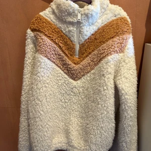 Vit fleece tröja 146/152 - Mysig vit fleece tröja med dragkedja och bruna och beige detaljer i ett V-mönster på bröstet. Kom inte till användning så därför säljer jag den.  Skicka gärna prisförslag!💕 Nypris: ca 400kr 