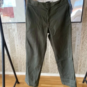 Gröna byxor från Dickies - Säljer ett par klassiska gröna byxor från Dickies, modell 874 Original Fit. Byxorna har en rak passform och är tillverkade i ett slitstarkt material. Perfekta för en avslappnad stil.