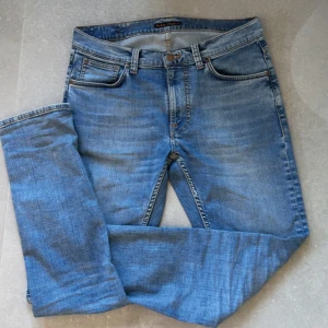 Blå jeans från Nudie - Snygga blå jeans i modellen Lean Dean med en klassisk femficksdesign. Tillverkade i 98% bomull och 2% elastan för en bekväm passform. Perfekta för en avslappnad stil. Storlek 31/32
