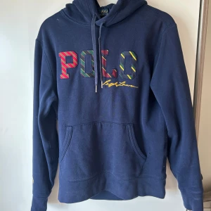 Mörkblå hoodie från Ralph Lauren - Säljer en snygg mörkblå hoodie från Ralph Lauren med POLO-tryck på bröstet. Hoodien är i storlek M 