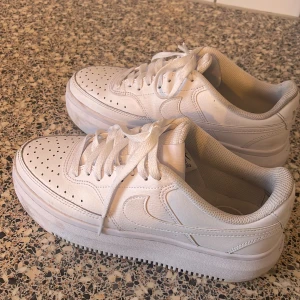 Vita sneakers från Nike - Snygga vita sneakers från Nike med klassisk design och perforerade detaljer för extra ventilation. Skorna har en robust sula och snörning för en säker passform. Perfekta för en stilren look. Har använt de 1-2 dagar. Storlek 39