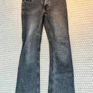 Grå bootcut jeans - Snygga grå bootcut jeans med en klassisk femficksdesign. Jeansen har en lätt tvättad look och är perfekta för en avslappnad stil. De har en bekväm passform och är tillverkade i ett slitstarkt material.