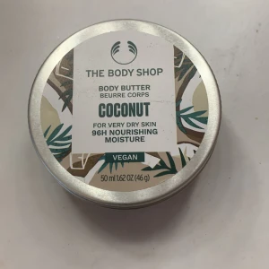 Body Butter Coconut från The Body Shop - Body Butter med kokosdoft från The Body Shop, perfekt för mycket torr hud. Ger 96 timmars närande fukt och är vegansk. Förpackningen innehåller 50 ml och är tillverkad av återvunnen plast.