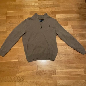 Beige tröja från Ralph Lauren - Snygg beige tröja från Ralph Lauren med dragkedja vid halsen. Använd men har fortfarande mycket att leva för. Pris kan diskuteras vid snabb affär:)