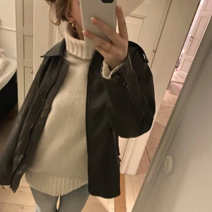 Vit stickad polotröja - Säljer en mysig vit stickad polotröja med långa ärmar och ribbade detaljer vid ärmslut och nederkant.  Passar bra till jeans eller kjol.