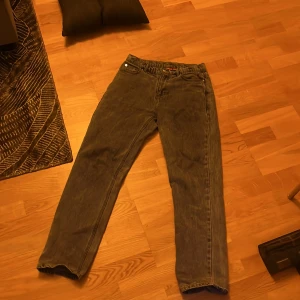 Grå jeans från RYVLS - Säljer ett par grå jeans från RYVLS i modellen Urban Loose Denim. Byxorna har en loose passform och är tillverkade i 100% bomull. Perfekta för en avslappnad stil.