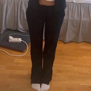 Svarta bootcut byxor - Säljer ett par svarta bootcut byxor med normal passform. Byxorna har klassisk design och är perfekta för en stilren look. Passar till många olika outfits och är ett måste i garderoben.