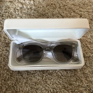 CHIMI 02 Grå transparenta solglasögon  - Snygga solglasögon från CHIMI i transparent grå plast med mörka glas. Rektangulär form och stilren design, perfekt för dig som vill ha en modern accessoar. Kommer med originalfodral och putsduk.