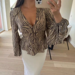 Adoore zebra blouse  - Säljer denna populära och ursnygga topp från Adoore. Säljs pga köpte flera storlekar, helt slutsåld på hemsidan. DENNA TOPPEN ÄR SÅ PERFEKT, sitter supersnyggt!!💌👌🏽helt ny med prislapp