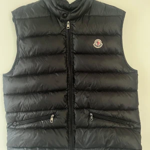 Moncler gui väst - Nu ska jag sälja min snygga stilrena svarta Moncler gui väst st 3 liknande M i herr storlek. Den är äkta med fullt fungerande nfc Scan och tags. Västen har inga skador eller defekter förutom 1 liten fläck som man kan få bort i tvätten (se på bilderna). Priset är inte hugget i sten och skriv gärna vid frågor eller funderingar😁