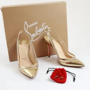 Guldiga klackar från Christian Louboutin - Säljer ett par exklusiva klackar från Christian Louboutin i guldigt skinn med transparenta detaljer och klassisk röd sula. Skorna har spetsig tå och hög klack 100mm, perfekta för dig som vill sticka ut med lyxig stil.
