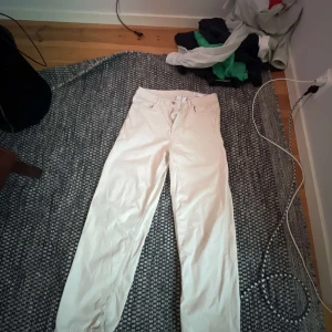 Beiga raka jeansbyxor - Säljer ett par beiga jeansbyxor med normal passform och raka ben. Klassisk femficksmodell med knappar och dragkedja i gylfen. Perfekta för en stilren och enkel look.