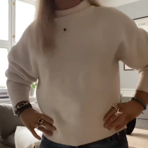 Vit stickad tröja från Zara - Säljer en vit, mjuk och stickad tröja från Zara med hög hals. Tröjan har lång ärm och ribbade muddar vid ärmslut och nederkant. Perfekt för lager-på-lager och enkel att matcha med jeans eller kjol.