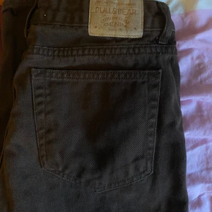 Bruna mid waist jeans från Pull&Bear - Säljer ett par bruna jeansbyxor från Pull&Bear med klassisk femficksdesign och raka ben. Byxorna har normal passform och är tillverkade i bomull. Perfekta för dig som gillar en enkel och stilren look.