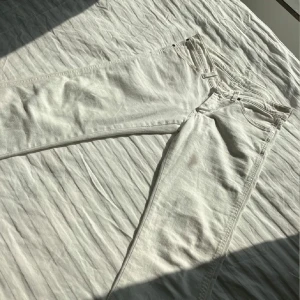 Vita jeansbyxor från Wrangler - Säljer ett par vintage vita lågmidjade jeansbyxor från Wrangler med klassiska bakfickor. Byxorna har ”bootcut ben” och normal passform, perfekta för en stilren look. Ikonisk Wrangler-lapp på bakfickan.