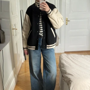 Svart och beige varsityjacka från H&M - Säljer denna beiga och svarta collegejacka från H&M. Den är i storlek S och är i mycket fint skick!