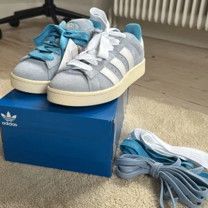 Adidas Campus 00s ljusblå - Säljer ett par helt oanvända Adidas Campus 00s sneakers i ljusblå mocka.🩵 3 olika snören medföljer (2 blåa och 1 vitt) . Strl 42 men passar även mig som har 40/41😇 Pris kan diskuteras vid snabb affär❤️‍🔥