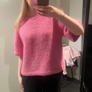 Rosa stickad tröja från Dobber - Säljer en  rosa stickad tröja från Dobber. Tröjan har kortare ärmar och en klassisk rund halsringning. 🩷
