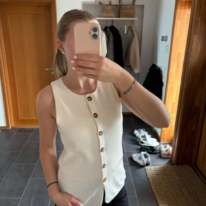 Vit ärmlös väst med knappar - Stilren cremevit väst med knappar, nyligen köpt på hm🐚ganska lång i modellen, relativt stor i storleken🩷