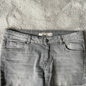 Grå jeansshorts från saint tropez - Snygga grå jeansshorts med klassisk femficksdesign och bälteshällor. Shortsen har en rak passform och är tillverkade i ett mjukt denimtyg. Perfekta för varma dagar och enkla att matcha med olika toppar.
