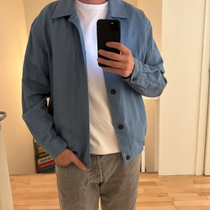 Blå overshirt från Zara - Säljer en stilren blå overshirt med klassisk krage och knäppning framtill. Jackan är från Zara och aldrig använd, storlek medium men funkar bra för large också. Priset går att diskutera fram om de så skulle viljas…