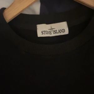 Svart sweatshirt från Stone Island - Säljer en svart sweatshirt från Stone Island med klassisk rund halsringning och lång ärm. Tröjan har en enkel och stilren design, perfekt för en avslappnad look. Ikonisk logga på ärmen. Nypris 3000kr+ mitt 700kr priset är ej hugget i en sten