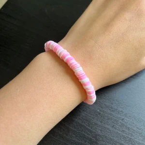Rosa och vit pärlarmband🩷 - Säljer ett armband med platta pärlor i olika nyanser av rosa och vitt. Armbandet är elastiskt och passar de flesta handleder. Perfekt för att addera lite färg till din outfit!🩷