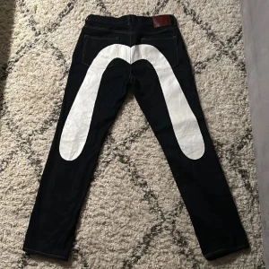 Svarta jeans med vit grafisk detalj - Säljs ej 