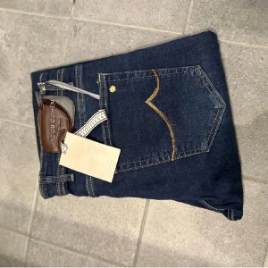 Jacob Cohen jeans LIMITED EDITION - Snygga mörkblå jeans från Jacob Cohen med klassisk femficksdesign och kontrastsömmar i gult. Byxorna har en läderpatch med logga bak och detaljerade sömmar på bakfickan. Perfekta för en stilren look. Helt nya. Modellen är Bard. LIMITED EDITION